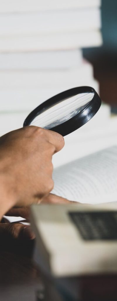 educational-theme-close-up-student-looking-through-magnifying-glass-book_1150-16611