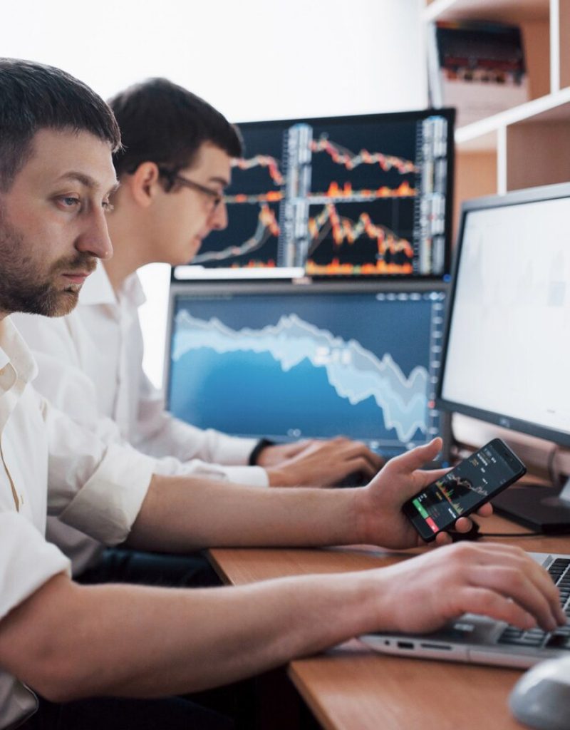 team-stockbrokers-are-having-conversation-dark-office-with-display-screens-analyzing-data-graphs-reports-investment-purposes-creative-teamwork-traders_146671-15025