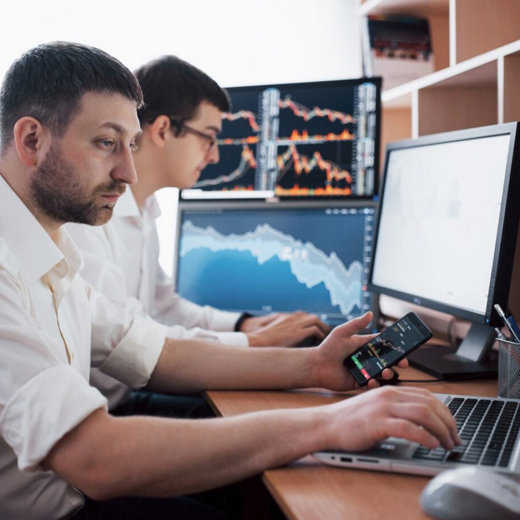 team-stockbrokers-are-having-conversation-dark-office-with-display-screens-analyzing-data-graphs-reports-investment-purposes-creative-teamwork-traders_146671-15025